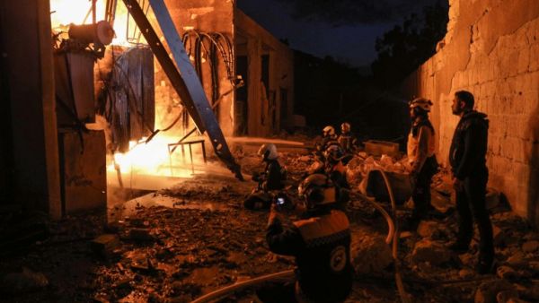 Members of the Syrian Civil Defence (The White Helmets) put out a fire at the site of reported air strikes inside the jihadist-held city of Idlib, on March 13, 2019. (AFP/ File)