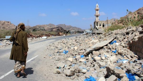 emeni fighter loyal to the government backed by the Saudi-led coalition walks past debris along a road near the town of Al-Shurayja in the southern Lahij province (AFP)