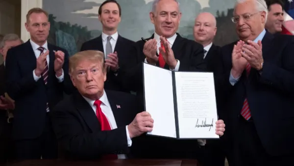 US President Donald Trump holds up a signed Proclamation on the Golan Heights alongside Israeli Prime Minister Benjamin Netanyahu in the Diplomatic Reception Room at the White House in Washington (AFP)