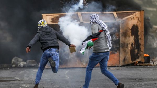 A Palestinian man throws back a tear gas canister during clashes with Israeli forces following a demonstration marking "Land Day" in the occupied West Bank on March 30, 2019. (AFP/ File photo)