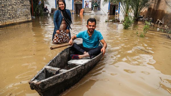 An Iranian man sits in a boat at his flooded garden in a village around the city of Ahvaz, in Iran's Khuzestan province (AFP)