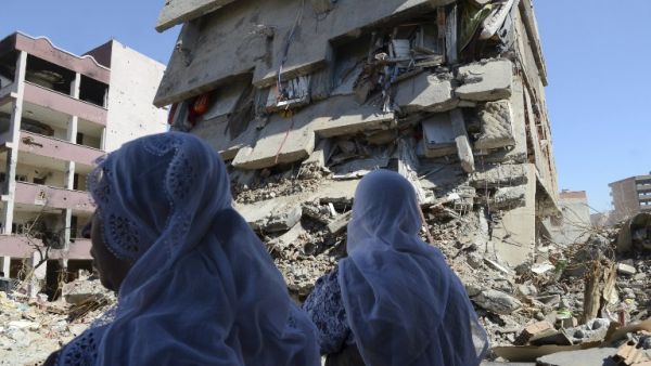 Women walk past the rubble of a damaged building following heavy fighting between government troops and Kurdish fighters in the Kurdish town of Cizre in southeastern Turkey, which lies near the border with Syria and Iraq, on March 2, 2016. (AFP/Ilyas Akengin)