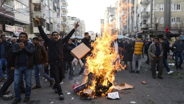People protest near a fire during clashes between Turkish forces and Kurdish people in the center of Diyarbakir, during a protest against a curfew in the Sur district of Diyarbakir, on March 2, 2016. (AFP/Ilyas Akengin)