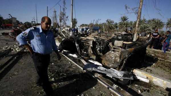 Iraqi emergency responders inspect debris at the site of a truck bomb, that exploded at a crowded checkpoint, in the Iraqi city of Hilla, south of Baghdad on March 6, 2016. (AFP/Haidar Hamdani)
