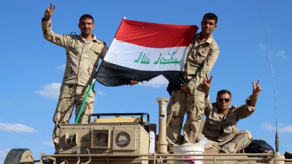 Iraqi government forces wave the national flag from their vehicles in the village of Mohammadi, a few miles north of Hit, in Iraq's western province of Anbar on March 18, 2016. (AFP/Moadh al-Dulaimi)