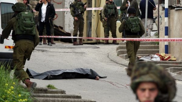 Israeli soldiers surround the body of one of the two Palestinians who were killed after wounding an Israeli soldier in a knife attack before being shot dead by troops in Hebron on March 24, 2016. (AFP/Hazem Bader) Israeli soldiers surround the body of one of the two Palestinians who were killed after wounding an Israeli soldier in a knife attack before being shot dead by troops in Hebron on March 24, 2016. (AFP/Hazem Bader)