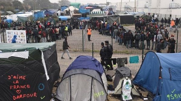 Migrants line up for transportation by bus to reception centers across France, from the "Jungle" migrant camp in Calais, northern France, on Oct. 24, 2016 (FRANCOIS LO PRESTI/AFP)