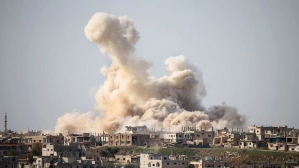 Smoke billows following air strikes in the southern city of Daraa (AFP/File Photo)