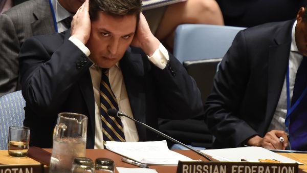 Russia's deputy UN ambassador, Vladimir Safronkov, covers his ears during a Security Council debate on Syria, April 5 2017. (AFP/Timothy A. Clary)