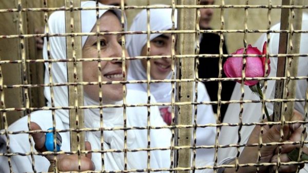Women prisoners look out a barred window of Al-Qanater prison in Cairo (AFP/File Photo)

