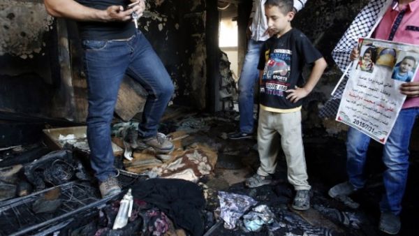 Palestinians inspect the damage as they stand in a house in the West Bank village of Duma set on fire in an apparent attack by Jewish terrorists, which killed 18-month-old Palestinian toddler Ali Saad Dawabsha on July 31, 2015. (AFP/Thomas Coex)