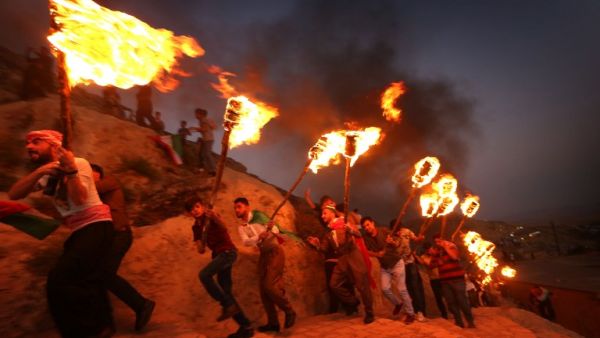 Iraqi Kurds wave Kurdish flags and hold torches as they walk up a mountain during a gathering to show support for the upcoming independence referendum and encourage people to vote in the town of Akra, some 500 kilometres north of Baghdad on September 10, 2017. (SAFIN HAMED / AFP)