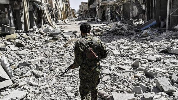 A member of the Syrian Democratic Forces (SDF) sprints through the debris in the old city center on the eastern frontline of Raqqa. (AFP /BULENT KILIC)