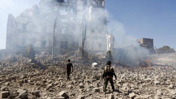Huthi rebel fighters inspect the damage after a reported air strike carried out by the Saudi-led coalition targeted the presidential palace in the Yemeni capital Sanaa on Dec. 5, 2017 (Mohammed Huwais/AFP)