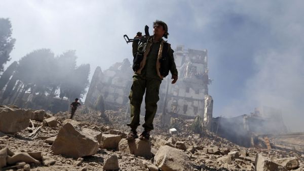 Houthi rebel fighters inspect the damage after a reported air strike carried out by the Saudi-led coalition targeted the presidential palace in the Yemeni capital Sanaa on Dec. 5, 2017. (Mohammed HUWAIS / AFP)