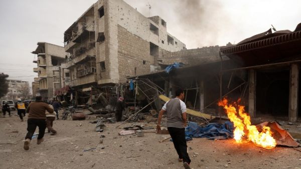 Civilians and members of the Syrian Civil Defence, known as the White Helmets, run at the scene of a reported air strike on the city of Maaret al-Numan in Syria's rebel-held Idlib province on Jan. 3, 2018 (OMAR HAJ KADOUR/AFP)