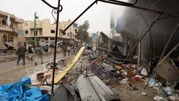 Civilians check the scene of a reported air strike on a market in the city of Maaret al-Numan in Syria's rebel-held Idlib province on Jan. 3, 2018 (OMAR HAJ KADOUR/AFP)