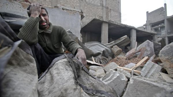 A Syrian man mourns over his destroyed home in the rebel-held besieged town of Arbin, in the eastern Ghouta region on the outskirts of the capital Damascus on Feb. 5, 2018, following airstrikes (ABDULMONAM EASSA / AFP)