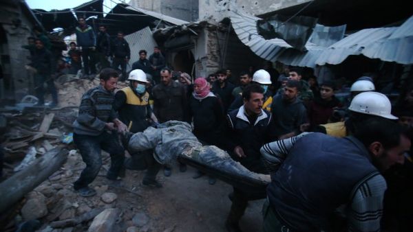Members of Syrian civil defense forces known as the White Helmets evacuate a victim of an air strike in the rebel-held enclave of Arbin in the Eastern Ghouta near the capital Damascus on Feb. 9, 2018 (ABDULMONAM EASSA / AFP)