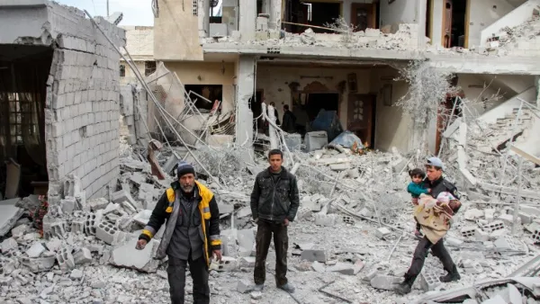 Syrian civil defense volunteers stand amid debris and destruction following a reported regime airstrike in the besieged town of Douma in the Eastern Ghouta region, on the outskirts of the capital Damascus, on Feb.15, 2018. 
(Hamza Al-Ajweh / AFP)