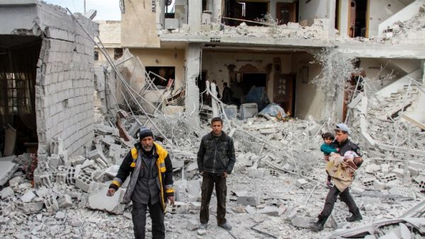 Syrian civil defense volunteers stand amid debris and destruction following a reported regime airstrike in the besieged town of Douma in the Eastern Ghouta region, on the outskirts of the capital Damascus, on Feb.15, 2018. 
(Hamza Al-Ajweh / AFP)