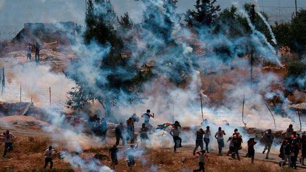 "Gado, 32, a cameraman for the Palestinian News Network, took off the mask he was wearing to protect himself from the tear gas and gave it to the woman." (Facebook)