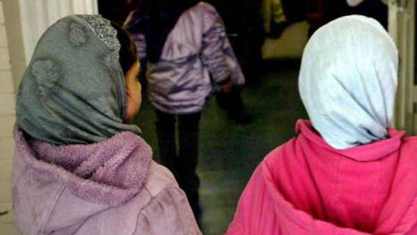 Investigation into online abuse targeting the head teacher of an East London where girls younger than the age of eight were banned from wearing the hijab (AFP)