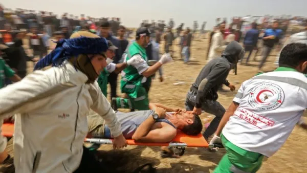 Palestinians evacuate an injured protester during clashes with Israeli security forces (AFP/File Photo)	