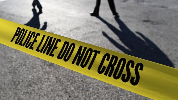 Police officers stand behind crime scene tape (AFP/File Photo)	