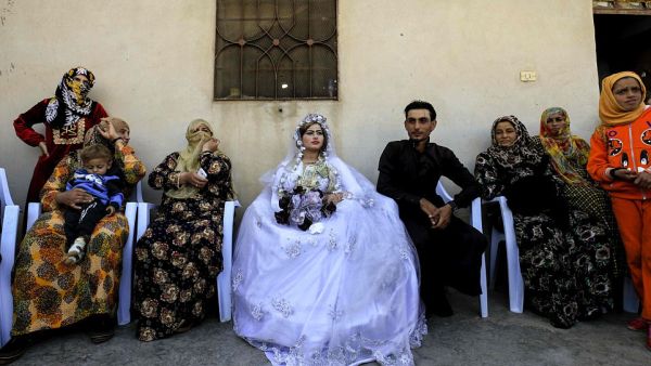 Around the couple, guests took photos with mobile phones while little girls also made-up with darkened eyebrows and colored lips danced to the beat of the music (AFP)