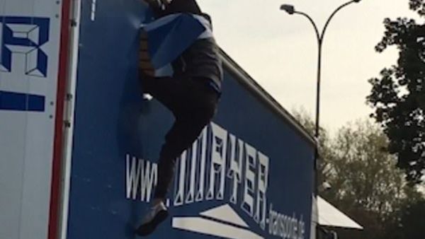 The first man climbed down athletically, though the second (pictured) struggled a bit. Both were dressed in dark clothes and tried to keep their faces covered (dailymail)