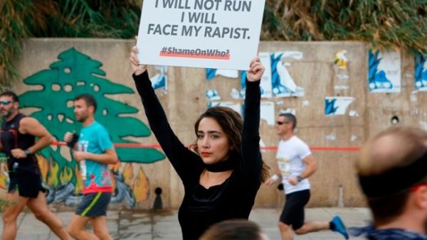 A protester holds a banner with a message against sexual assault during the 16th edition of the Beirut Marathon in the Lebanese capital on November 11, 2018. (AFP / Abaad / Marwan TAHTAH)
