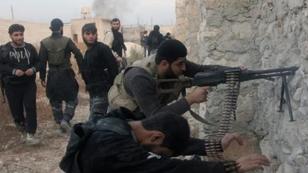 Syrian rebel fighters shoot through a hole in a wall towards forces loyal to the regime in Aleppo.(AFP / File)


