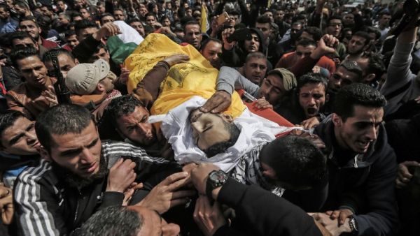 Palestinian mourners carry the body of Mousa Mousa,23, during his funeral in Deir al-Balah in the central Gaza Strip (AFP)