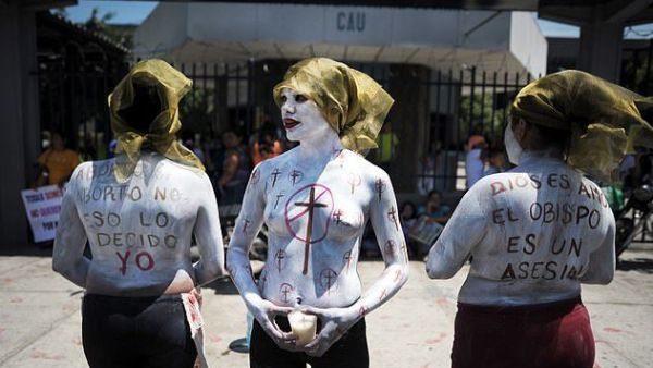 Imelda Cortez, 20, is facing 20 years in jail after she was charged with attempted murder for giving birth to her abuser's baby in a toilet in El Salvador. Pictured: Members of a feminist organisation demonstrate in favour of abortion rights outside the Courthouse of San Salvador  (AFP)
