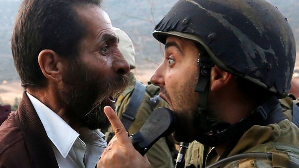 A Palestinian man argues with an Israeli soldier (Twitter)
