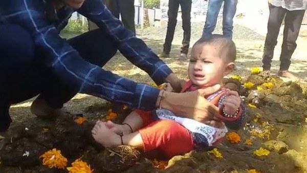 Crying children are placed in cow dung (Twitter)