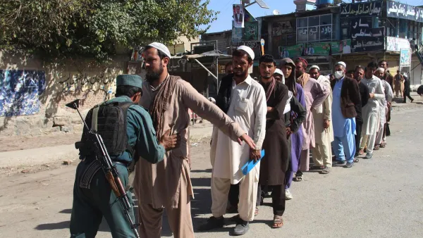 An Afghan policeman searches voters before casting their votes at a polling centre for the country's legislative election in Khost Province on October 20, 2018. (AFP/File)