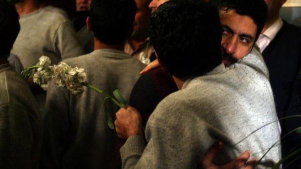 Iranian men who had been held hostage by Syrian rebels since early August hug each other as they arrive at a hotel in Damascus after being freed in a prisoner swap. (AFP PHOTO/LOUAI BESHARA)