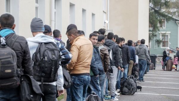 Afghan migrants wait in line at a Finnish reception center. (AFP/File)