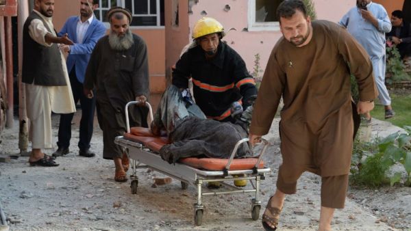 Afghan volunteers move a body from the scene of a suicide attack that targeted the national television station in Jalalabad on May 17, 2017. (AFP/Noorullah Shirzada)