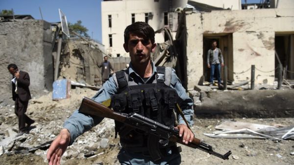 Afghan security personnel keep watch in front of the entrance to the charity organization following a car bomb blast that targeted the CARE International compound at Shar-e-Naw in Kabul on September 6, 2016. (AFP/Wakil Kohsar)
