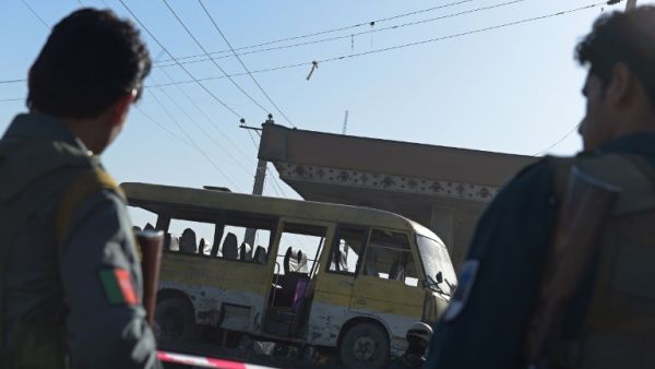 Afghan policemen look at the site of a suicide attack to have hit a minibus carrying foreign security guards in Kabul on June 20, 2016. (AFP/Shah Marai)