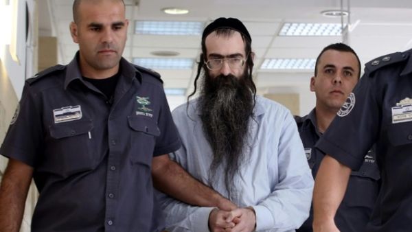 Ultra-Orthodox Jew Yishai Shlissel, who was convicted of killing a 16-year-old Israeli girl during the Jerusalem Gay Pride parade last year, is escorted into court by police on June 26, 2016 in Jerusalem. (AFP/Gail Tibbon)