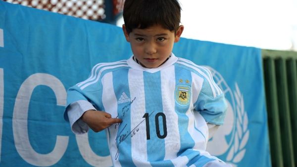 Afghan boy Murtaza Ahmadi proudly wears one of the jerseys sent by his idol Lionel Messi. (AFP/Mahdy Mehraeen)