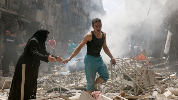 People walk amid the rubble of destroyed buildings in Aleppo. (AFP/File) 
