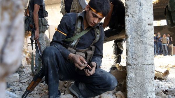 A rebel fighter reloads his weapon during clasahes with regime forces in Ramussa on the southwestern edges of Aleppo on August 6, 2016. (AFP/Fadi A-Halabi)