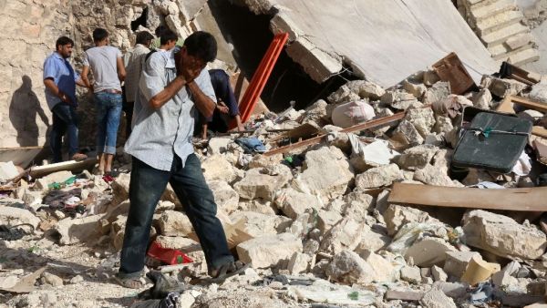 A Syrian man reacts as rescuers look for victims under the rubble of a collapsed building following a reported air strike in Aleppo on July 19, 2016 (AFP/Thaer Mohammed)