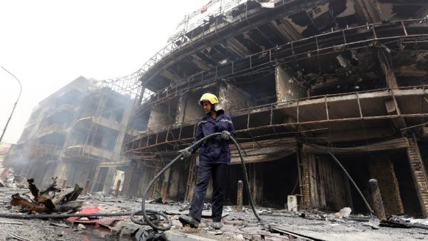 An Iraqi firefighter works at the site of a Baghdad bombing claimed by the Islamic State group on July 3. (AFP/Sabah Arar)
