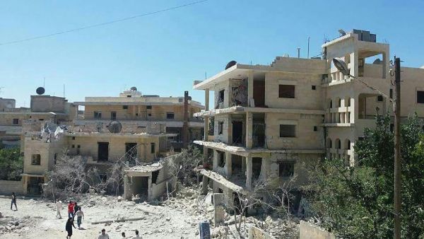 People gathering in front of the damaged building of a maternity hospital supported by Save the Children after it was hit by an air raid in the rebel-held town of Kafar Takharim, in Idlib province of northwest Syria on July 29, 2016. (AFP/File)  